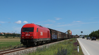 Corre affianco la trafficata strada statale la OBB 2016 028, con un merci da Ortmann verso Wiener Neustadt.