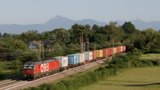 Transito poco prima di Tricesimo per la Vectron OBB 1293 004, impegnata con un variopinto treno container diretta a Trieste.